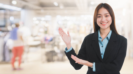 Portrait of Asian beautiful smiling businesswoman customer support on blurred interior shopping...