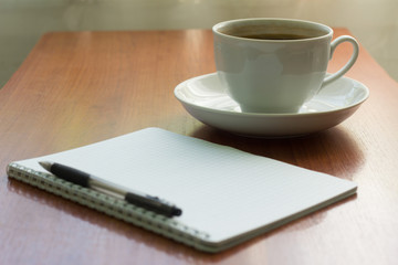 school notebook with pen and coffee Cup on table