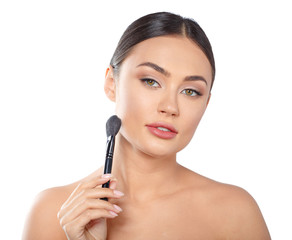 Beauty portrait of a playful beautiful half naked woman applying make-up with a brush