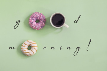 Sweet and colourful set of donuts with cup of coffee on the green background. Concept of good...
