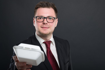 Portrait of business man handing lunch box.