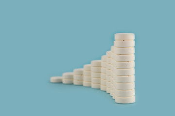Tablets of white color, laid in columns, the height of which is successively reduced on a blue background.