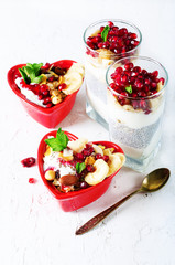 Healthy breakfast - pomegranate, yogurt, granola parfait on white concrete background. Romantic time.