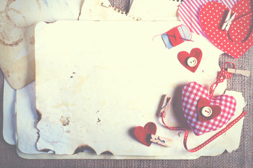 Red polka dot textile hearts on burlap. Free space for your text.