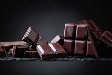Broken chocolate pieces on a black background.