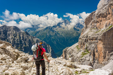 Female trekker walking along mountain valley.