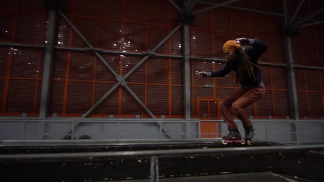 A man with dreadlocks roller-skating, slow motion