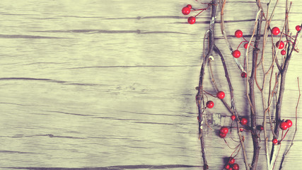Branch with berries on wooden background. Toned effect. Copy space