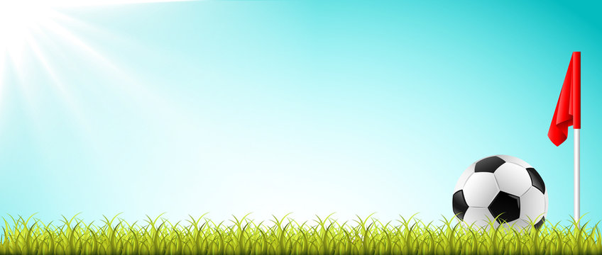 Fußball liegt auf dem Rasen mit Eckfahne und sonnigem blauen Himmel