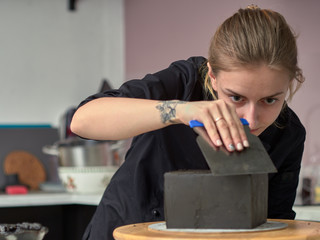Fototapeta premium Step-by-step preparation of black designer cake. The confectioner is applying a black frosting on the cake.