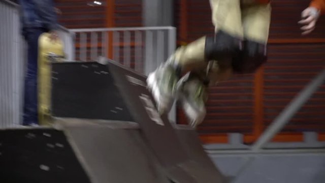 The tracking camera as a man on rollers rolls on a ramp in an extreme park