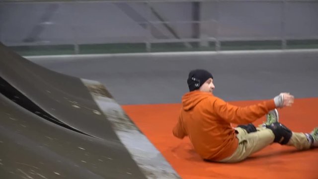 A pair of friends on rollers take turns on the ramp