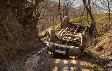 Fototapeta na wymiar Offroad rollover accident, car flipped on mountain road