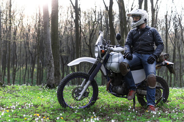 classic enduro motorcycle off road in spring forest, man in a stylish leather jacket, Motorcyclist gear, A motorcycle driver looks, concept, active lifestyle