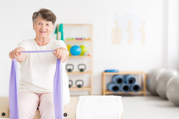 Exercising old woman at gym - obrazy, fototapety, plakaty