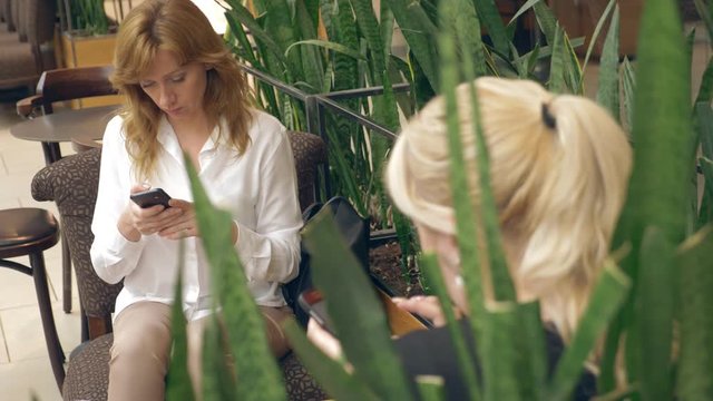 Woman talking on cellphone and drinking Coffee in cafe. 4k