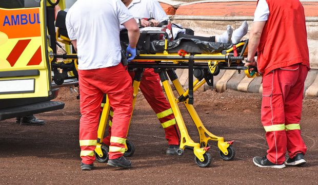 Ambulance stuff  with a stretcher on the sport track