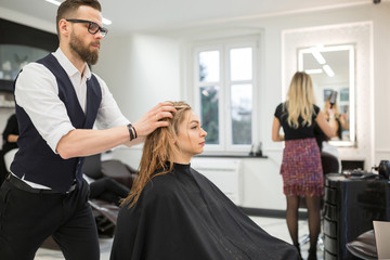 Hairdresser applying conditioner on customer hair