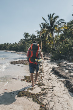 Cuba, Cienaga de Zapata, Backpacker walking on the beach, rear view