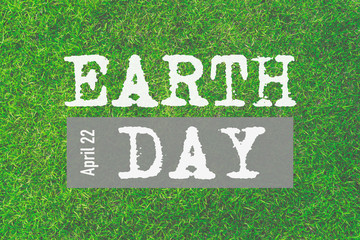 World Earth Day April 22. Earth day text on fresh Green grass texture background for spring or summer concept.