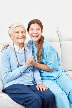 Pflegerin macht Hausbesuch bei glücklicher Seniorin