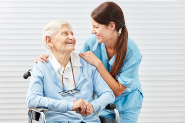 Krankenschwester mit einer alten Frau im Rollstuhl