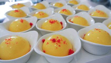 Dessert, mango custard in round shape served in small white bowl