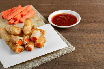 fried and fresh carrot stick served with ketchup on wooden table. homemade style snack concept.