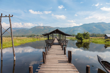Inle Lake, Myanmar. Wooden pillar bridge of Mine Thauk village is connection between land part and restaurant on the water. Also locals use it as walking area and meeting point to enjoy sunsets. 
