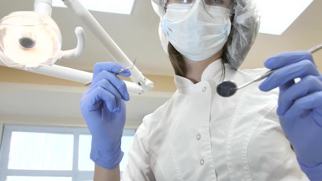 Dentist at work in dental clinic, during visit of client. Patient point of view