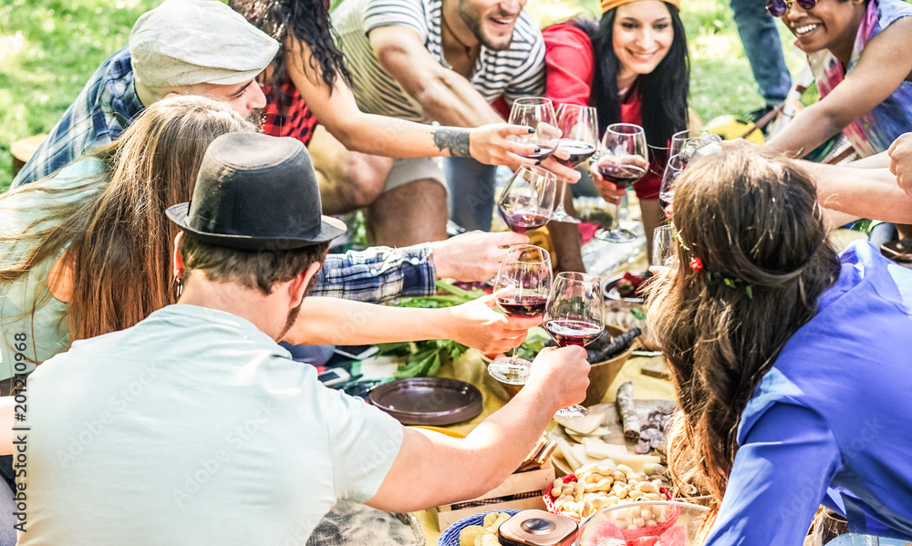 Wall mural group of happy friends cheering with red wine at picnic party in nature outdoor