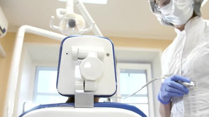 Dentist at work in dental unit with a girl lying client. Patient point of view
