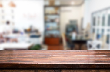 Selected focus empty brown wooden table and Coffee shop or restaurant blur background with bokeh image. for your photomontage or product display.