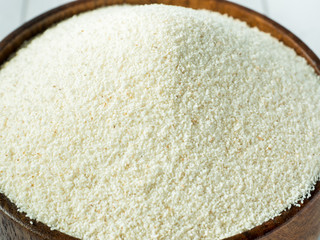 Semolina in a wooden bowl on a light background