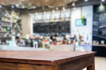 Selected focus empty brown wooden table and Coffee shop or restaurant blur background with bokeh image. for your photomontage or product display.