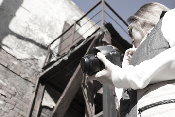 girl taking pictures with a camera abandoned, destroyed building