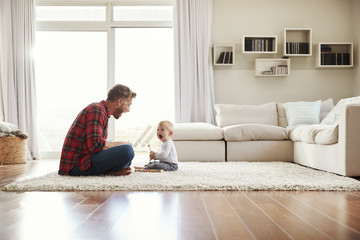 Young father and son playing together in their sitting room