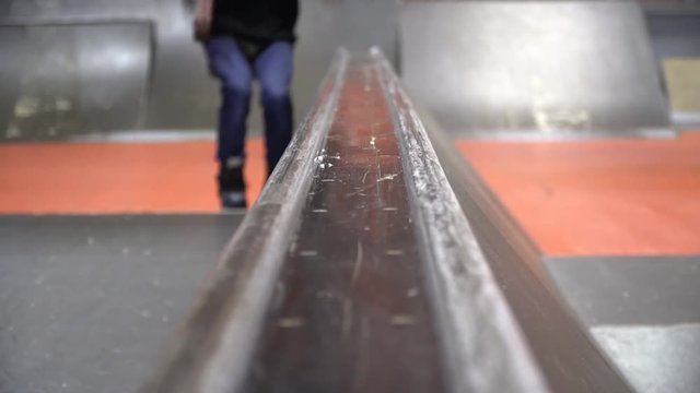 A man rollerblading in a skate park and performing a Niffty trick, slow motiond