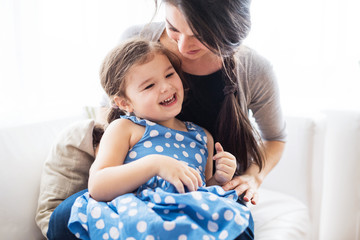 Young mother with a small girl at home.