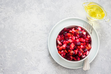 Fresh beetroot salad in a bowl on light concrete background.  Top view, copy space.