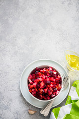 Raw beetroot salad in a bowl on light concrete background. Top view, copy space.