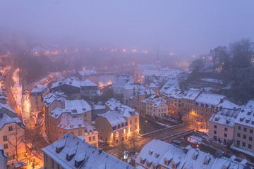 Grund, old town of Luxembourg city enveloped in early morning fog and covered in snow