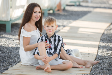 Summer portrait of mother and son on the beach. Happy family