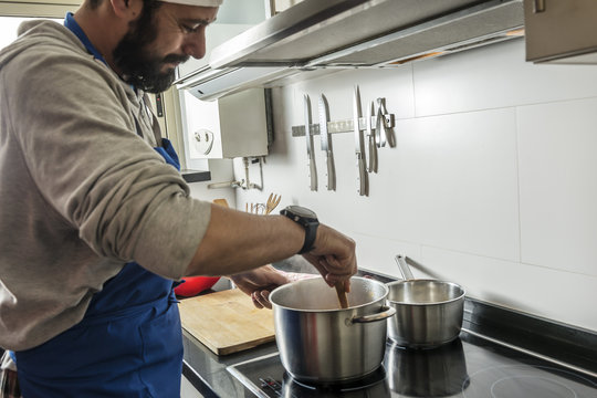 bearded man cooking in the home kitchen