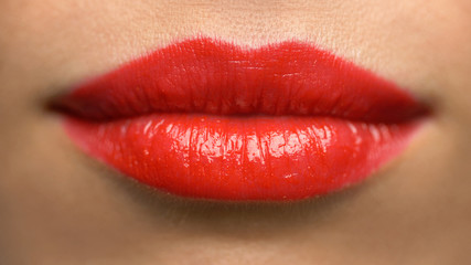 beauty, make up and people concept - close up of woman lips or mouth with red lipstick