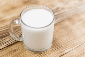 Obraz na płótnie Canvas Glass kefir (milk) on a wooden background. The concept of diet, weight loss.