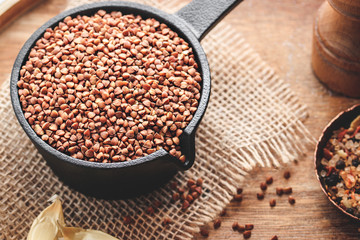 Buckwheat with spices on natural wooden background