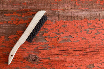 Cleaning brush against red wooden background