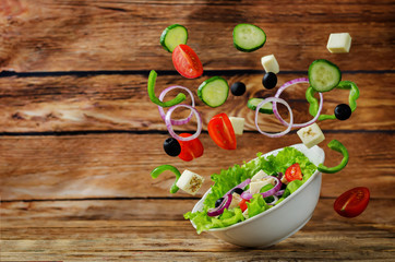 Greek Salad with flying ingredients to prepare it