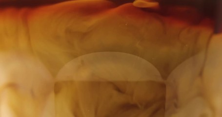 Close-up view of milk pouring in glass with black coffee - Powered by Adobe